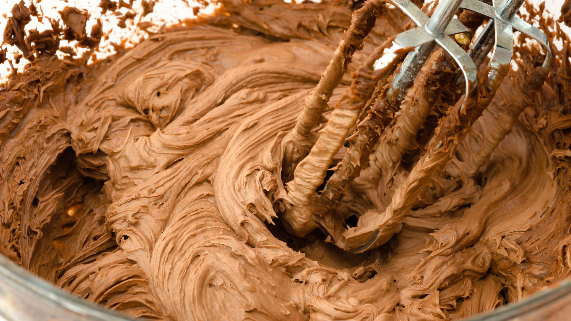 Quick Chocolate Buttercream Recipe blog post. An image of silky smooth chocolate buttercream in a mixing bowl.