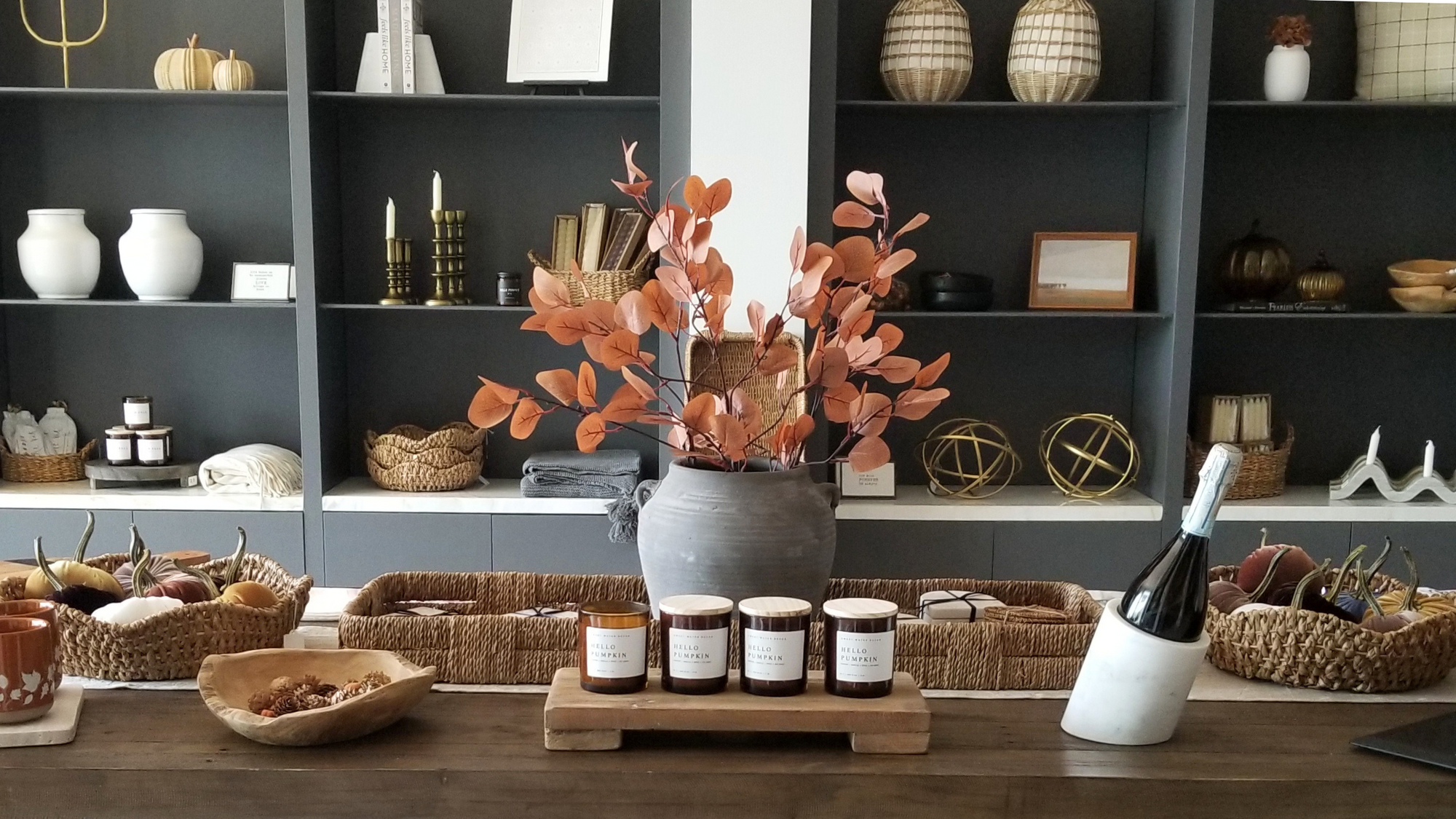 6 Easy Ways to Transition Your Home Decor For Fall blog post. Scene of table with vintage vase with fall florals, fall scented pumpkin candles, velvet pumpkins, woven baskets, vintage fall landscapes