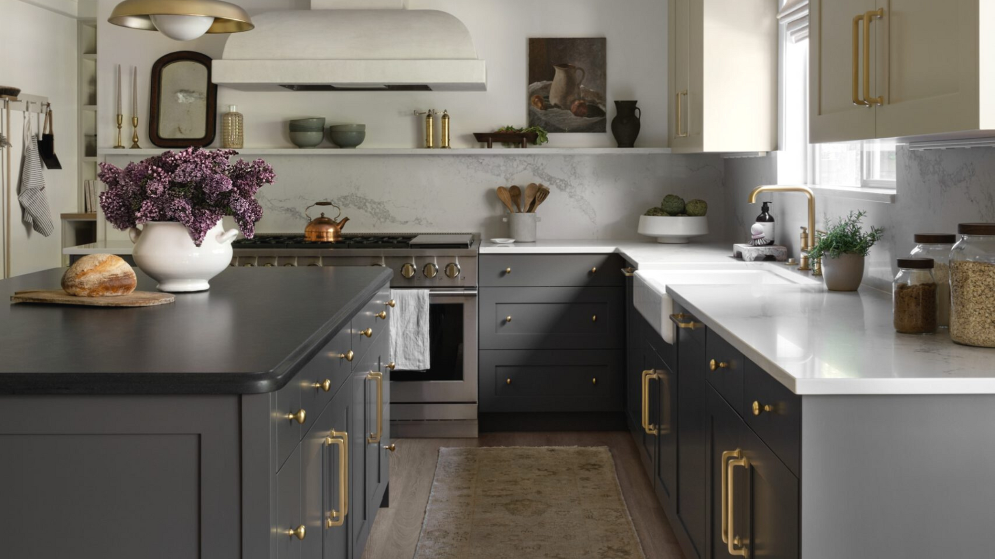Interior Design and Decor Trends for 2023 blog post. Kitchen scene with medium dark cabinets, veined marbled countertop and backsplash, vintage decor pieces, artwork, and vases.